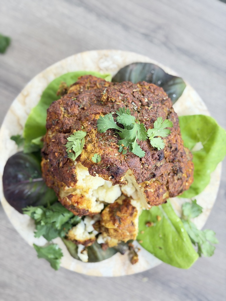 A whole cauliflower marinated in creamy spiced yogurt and roasted until golden, caramelized and tender